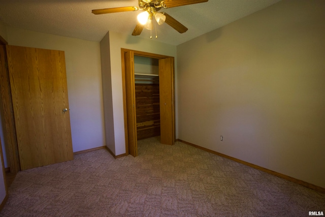 unfurnished bedroom with a textured ceiling, ceiling fan, light colored carpet, and a closet