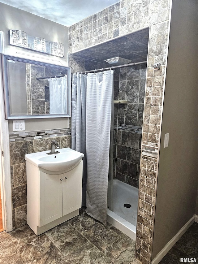 bathroom featuring walk in shower, tile walls, and vanity