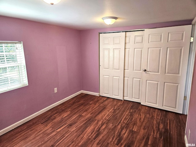 unfurnished bedroom featuring dark hardwood / wood-style flooring and a closet