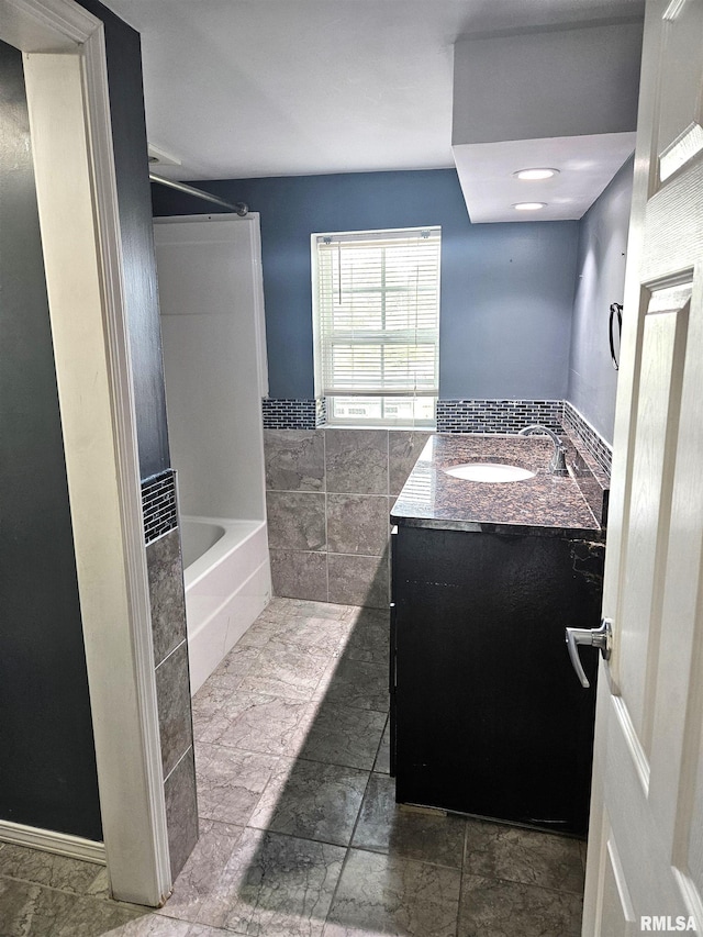 bathroom with vanity and washtub / shower combination