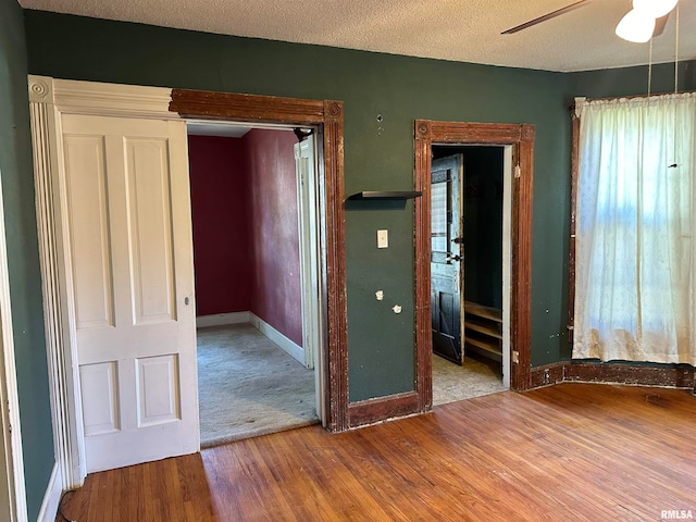 spare room with a textured ceiling, ceiling fan, and hardwood / wood-style flooring