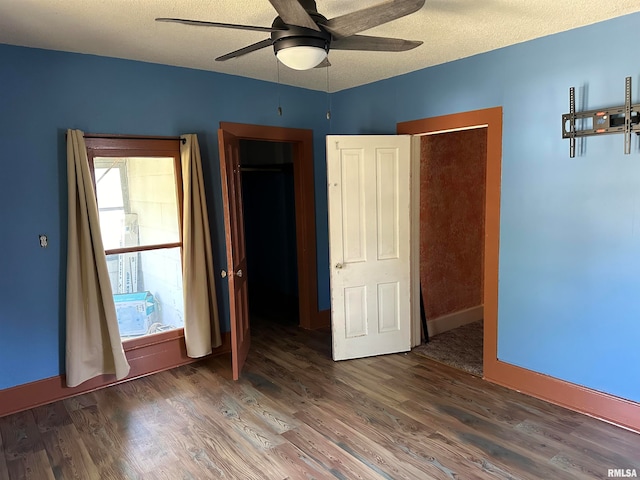 unfurnished bedroom with a textured ceiling, hardwood / wood-style floors, and ceiling fan