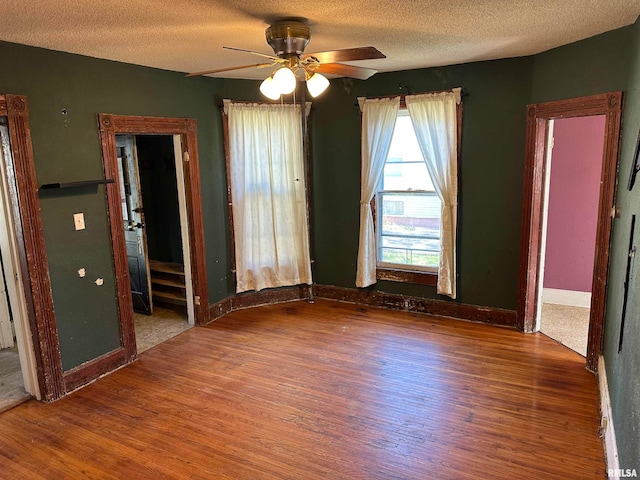 empty room featuring a textured ceiling, ceiling fan, and hardwood / wood-style flooring