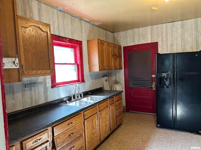 kitchen with black refrigerator with ice dispenser and sink