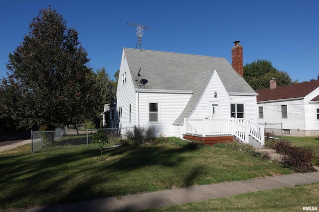 back of property with a deck and a yard