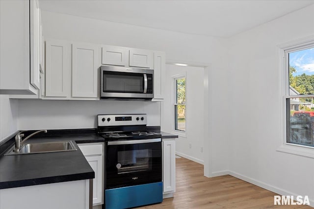 kitchen with white cabinets, appliances with stainless steel finishes, sink, and a wealth of natural light