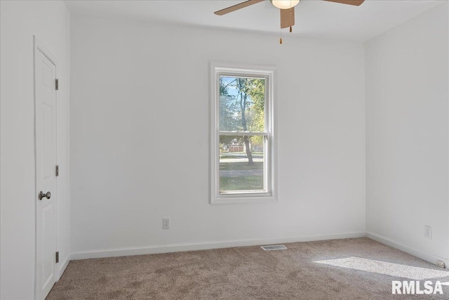 carpeted spare room featuring ceiling fan