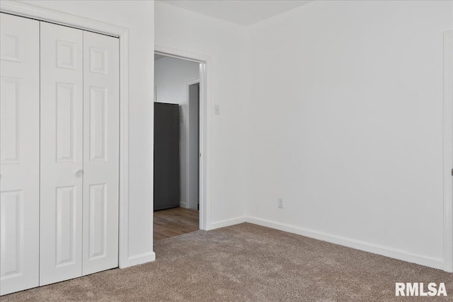 unfurnished bedroom with a closet and light carpet