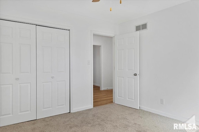 unfurnished bedroom with ceiling fan, a closet, and light colored carpet