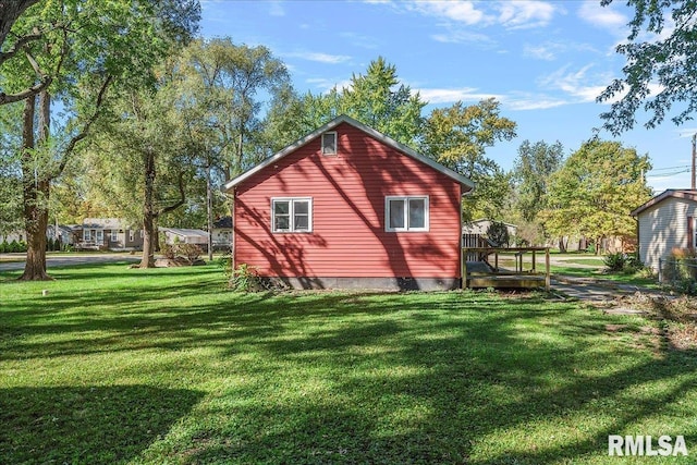 view of home's exterior featuring a wooden deck and a lawn