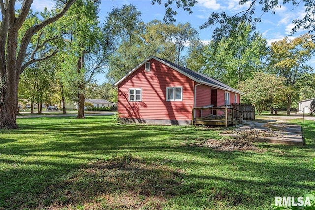 view of side of home with a wooden deck and a lawn