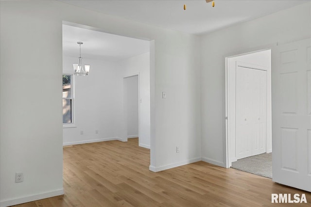 unfurnished room with hardwood / wood-style floors and an inviting chandelier