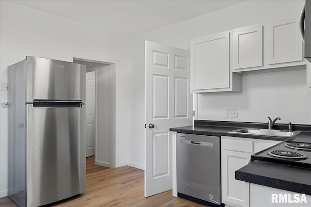 kitchen with light wood-type flooring, sink, stainless steel appliances, and white cabinets