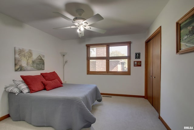 carpeted bedroom featuring ceiling fan and a closet