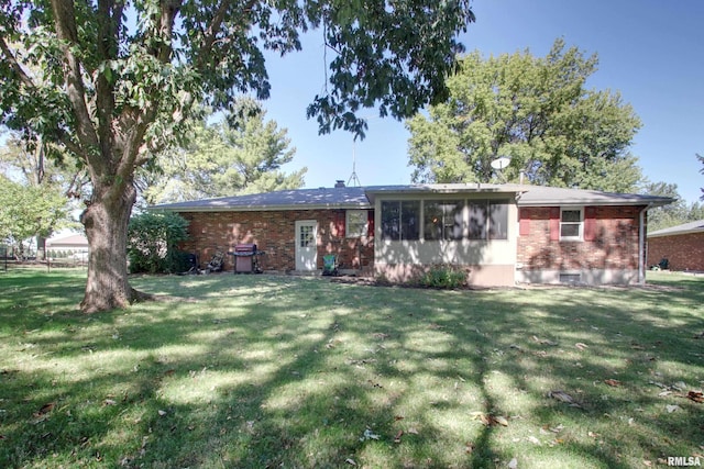 rear view of property featuring a lawn