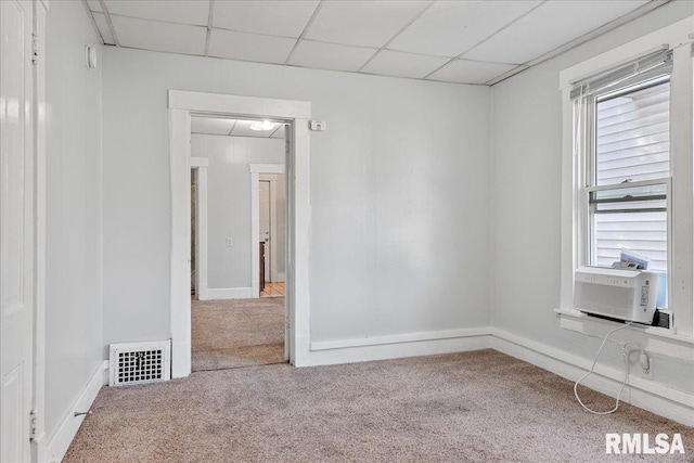 unfurnished room with carpet flooring, a paneled ceiling, a wealth of natural light, and cooling unit