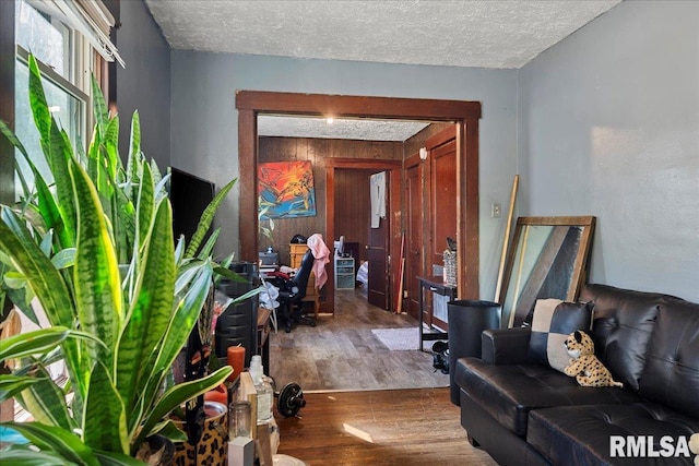 interior space featuring wooden walls, hardwood / wood-style floors, and a textured ceiling