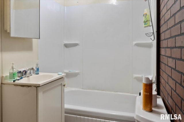 bathroom featuring vanity and brick wall