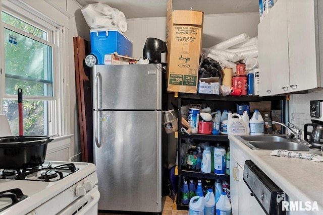 kitchen featuring white dishwasher, stainless steel fridge, white cabinetry, and sink