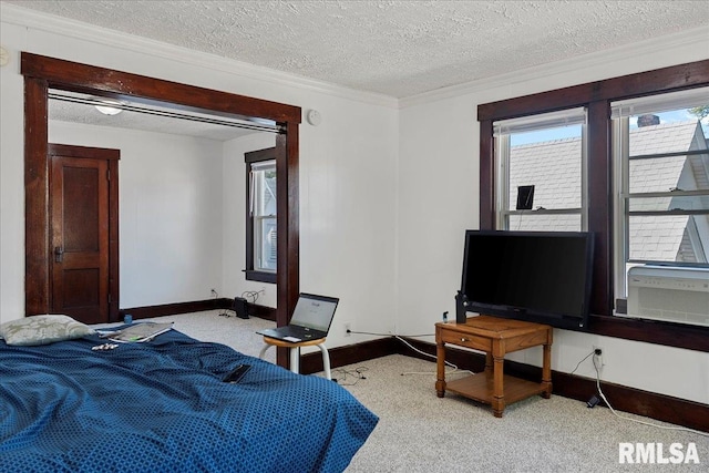 bedroom with a textured ceiling, light colored carpet, cooling unit, and ornamental molding