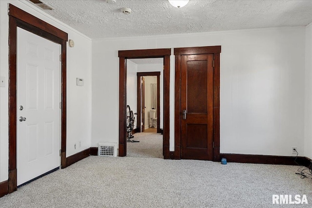 interior space featuring a textured ceiling and light carpet