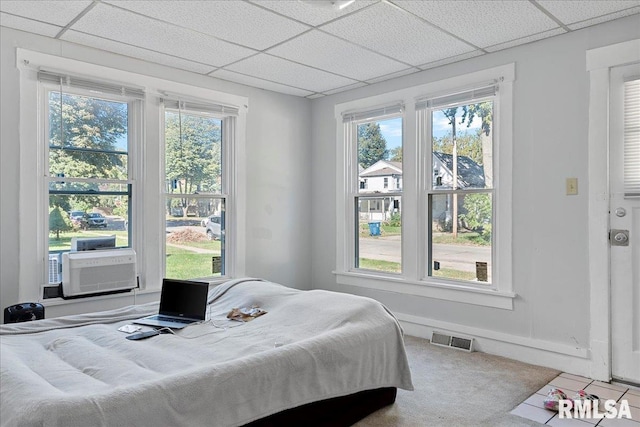 bedroom featuring tile patterned flooring, a drop ceiling, and cooling unit