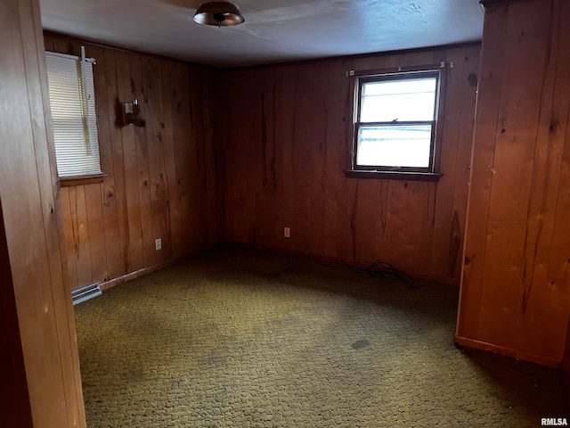 empty room with wooden walls and carpet flooring