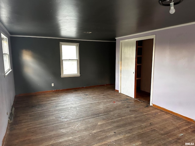 spare room with crown molding and dark hardwood / wood-style flooring