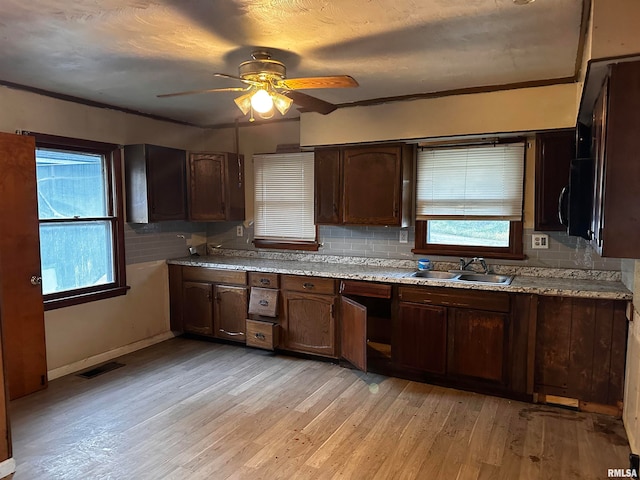 kitchen with ceiling fan, ornamental molding, sink, tasteful backsplash, and light hardwood / wood-style flooring