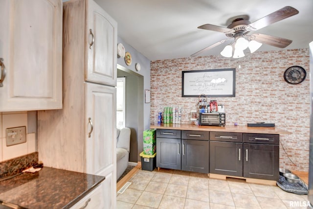 kitchen featuring dark brown cabinets, ceiling fan, white cabinetry, and light tile patterned floors