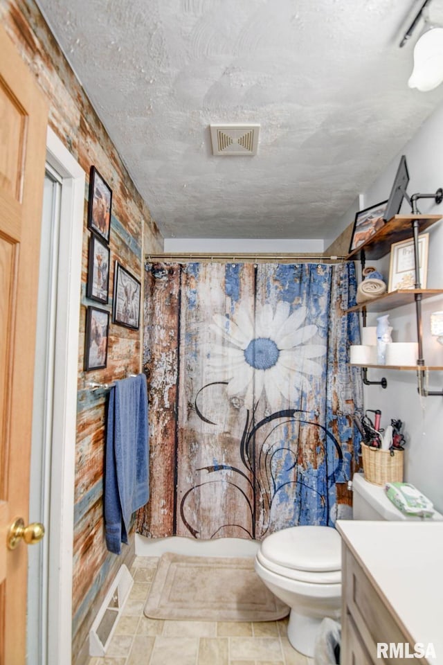 bathroom with walk in shower, vanity, and toilet