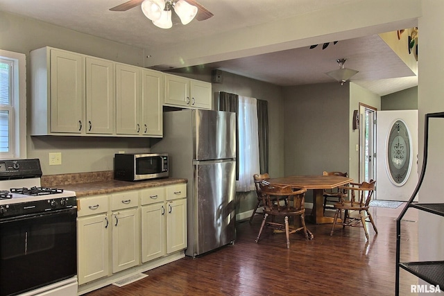 kitchen with ceiling fan, dark wood-type flooring, visible vents, lofted ceiling, and stainless steel appliances