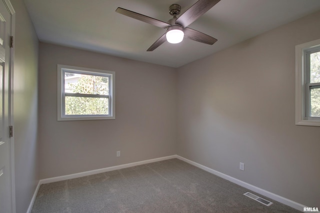 carpeted spare room with ceiling fan and a wealth of natural light