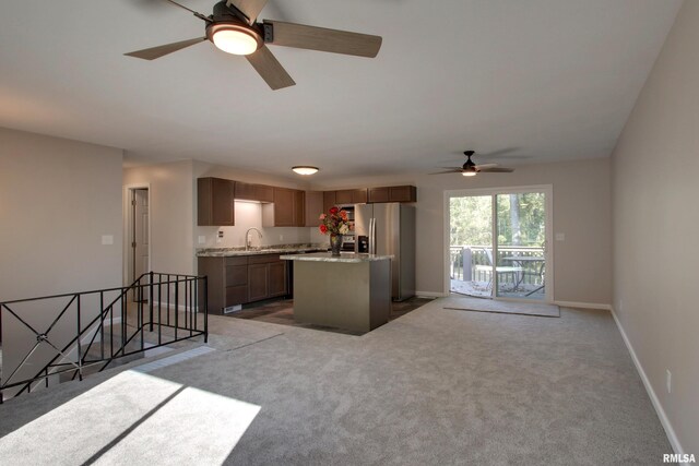 kitchen with a kitchen island, ceiling fan, stainless steel fridge, sink, and carpet flooring