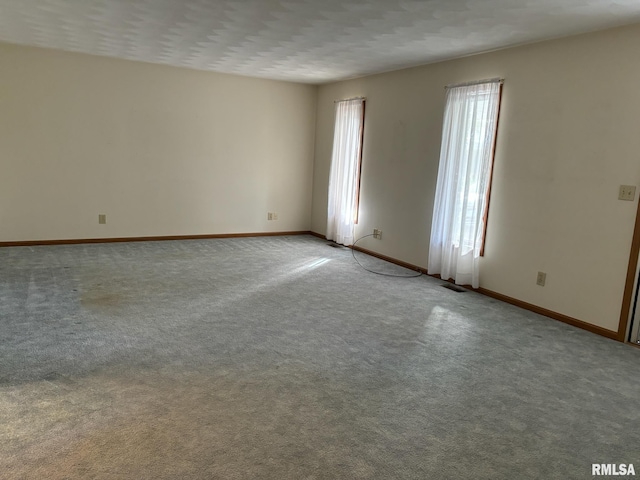 spare room featuring carpet and a textured ceiling