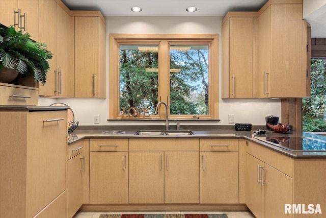 kitchen featuring a wealth of natural light, light brown cabinetry, black electric cooktop, and sink