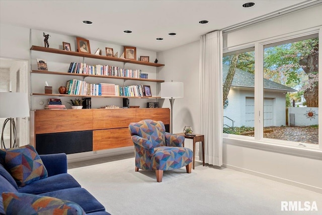 sitting room with a wealth of natural light and light carpet