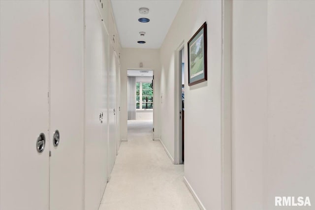 corridor featuring light colored carpet