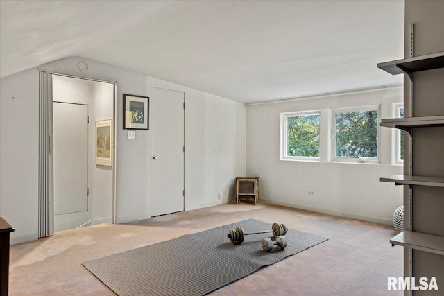 workout area with light carpet and vaulted ceiling