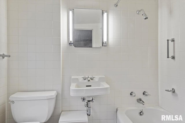 full bathroom with sink, tile walls, toilet, and tiled shower / bath