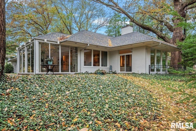 back of property with a sunroom