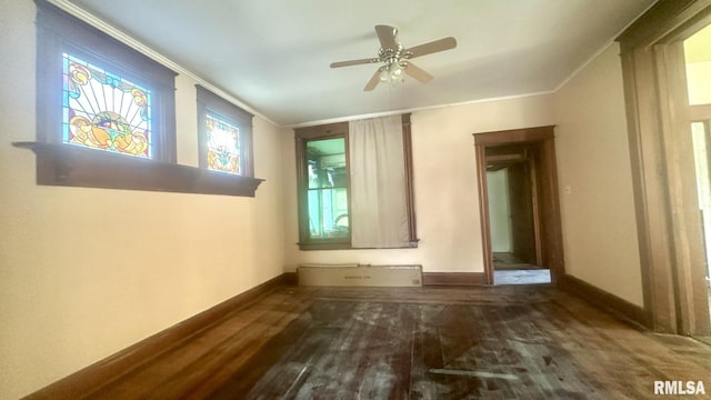 unfurnished room with ceiling fan, crown molding, and dark wood-type flooring