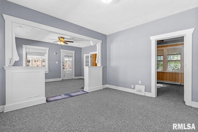 interior space with baseboard heating, ceiling fan, a textured ceiling, and dark colored carpet