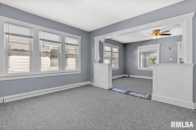 unfurnished room featuring ceiling fan, dark carpet, and a baseboard heating unit