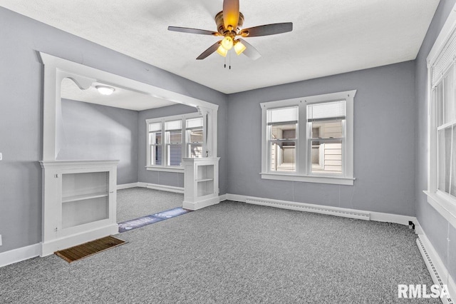 unfurnished room with baseboard heating, a textured ceiling, carpet floors, and ceiling fan