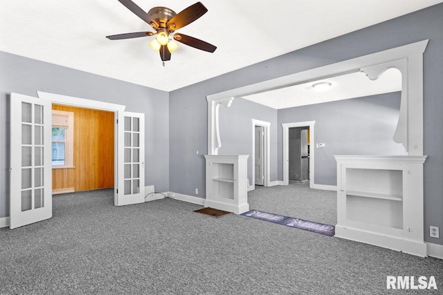 interior space with dark colored carpet, ceiling fan, and french doors