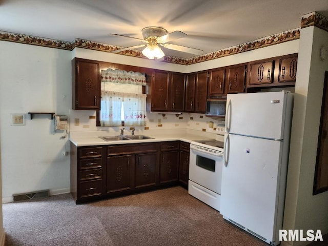 kitchen featuring white appliances, carpet flooring, sink, ceiling fan, and dark brown cabinetry