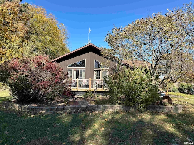 rear view of property featuring a deck and a yard