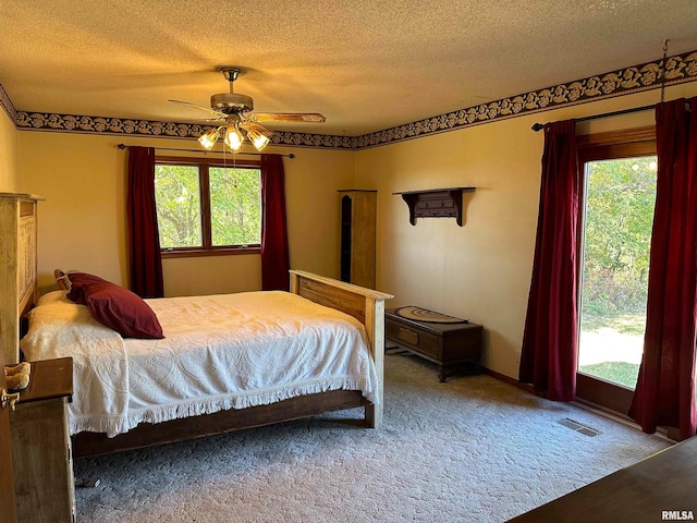 bedroom with a textured ceiling, carpet flooring, and ceiling fan