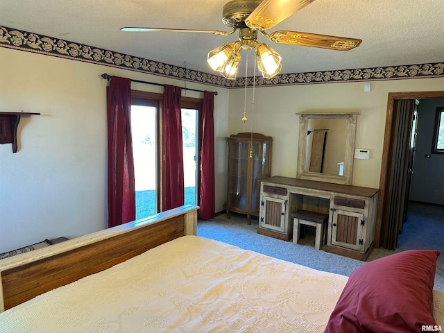 bedroom featuring ceiling fan, a textured ceiling, and light colored carpet